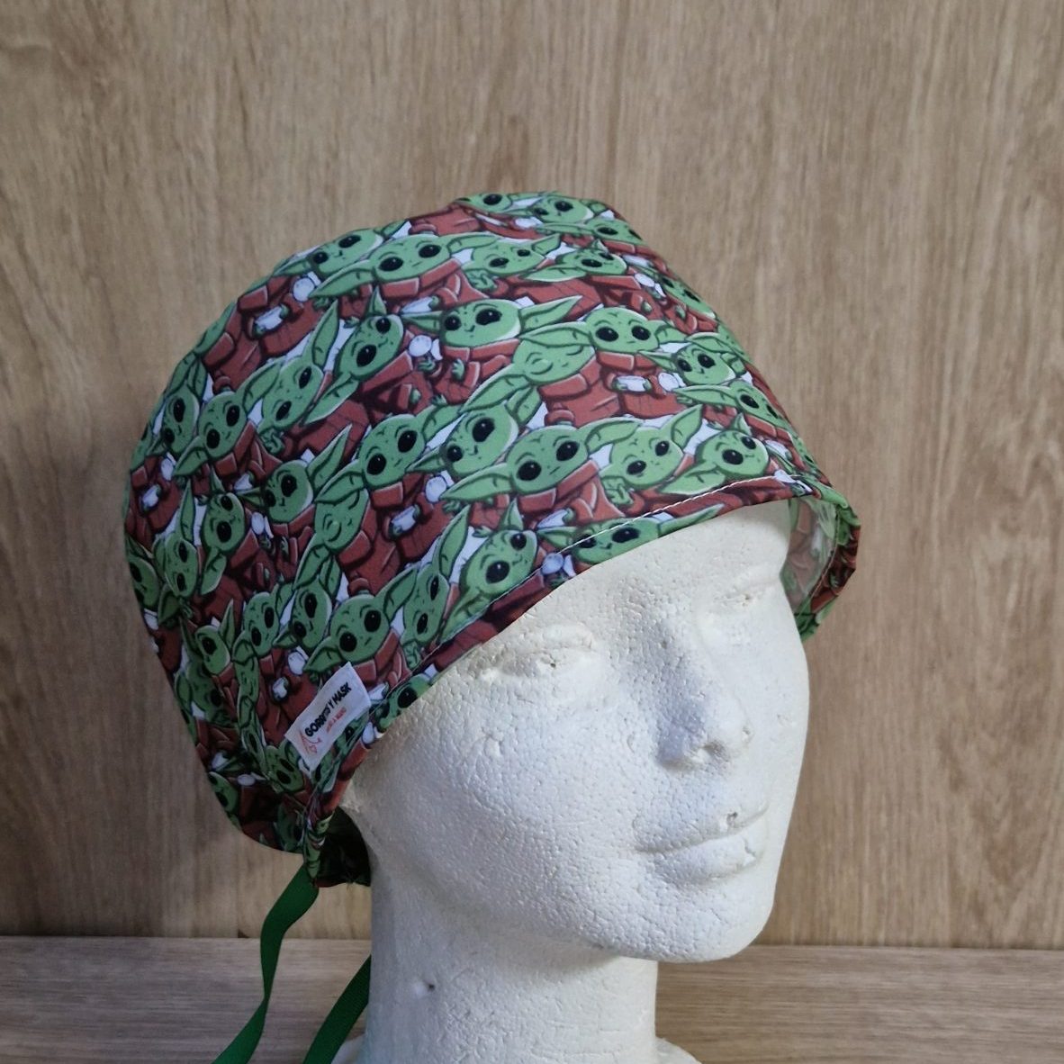 Gorro quirúrgico con estampado de Baby Yoda (Grogu) en fondo colorido, ideal para personal sanitario, cómodo y reutilizable.